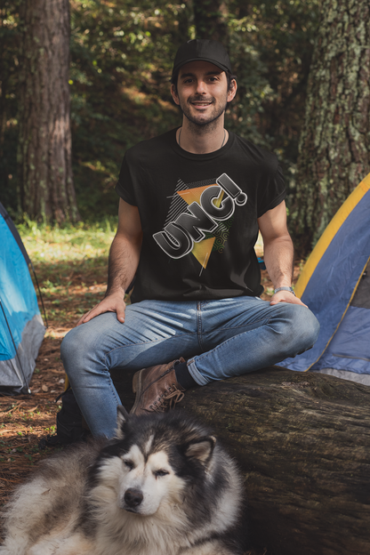 Man sitting with a dog in front of a tent in a forest
