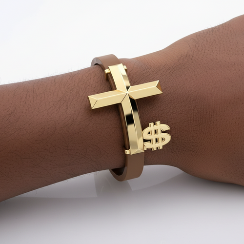 Gold bracelet with cross and dollar sign on a wrist against a white background