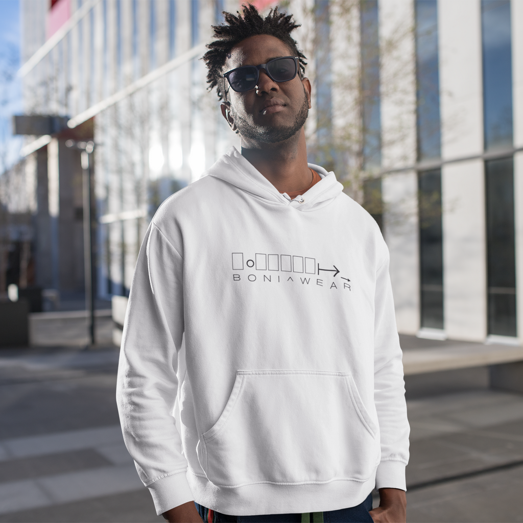 Man wearing a white hoodie with a logo and text, standing outdoors.